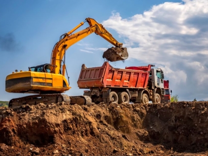 A construction site with rented excavators and dump trucks in operation