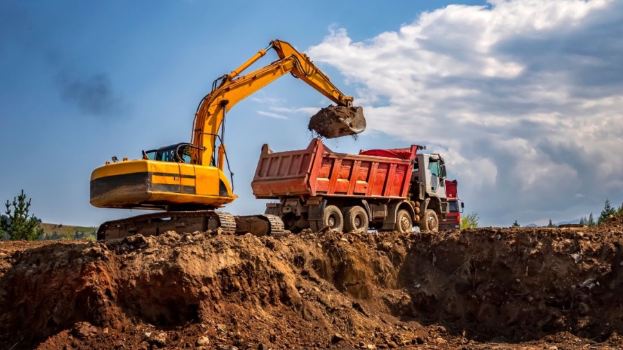 A construction site with rented excavators and dump trucks in operation