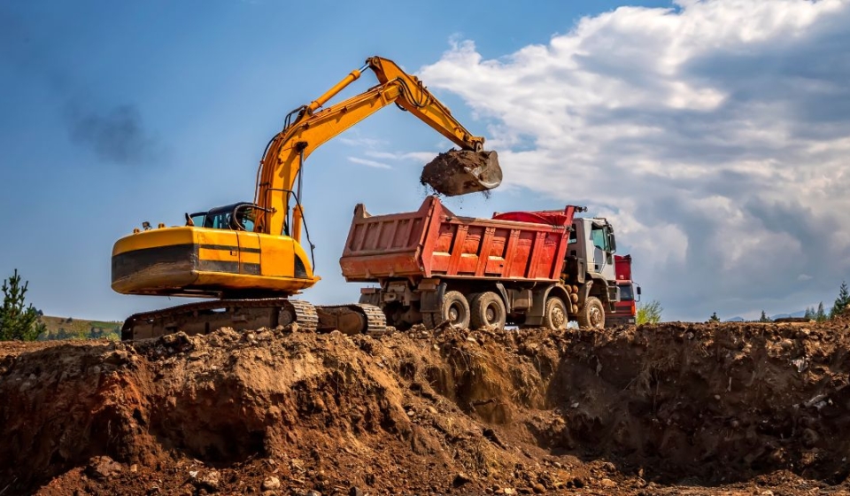 A construction site with rented excavators and dump trucks in operation